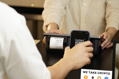 image of a check out counter with a My Crypto Merchant sticker announcing that the business takes crypto payments